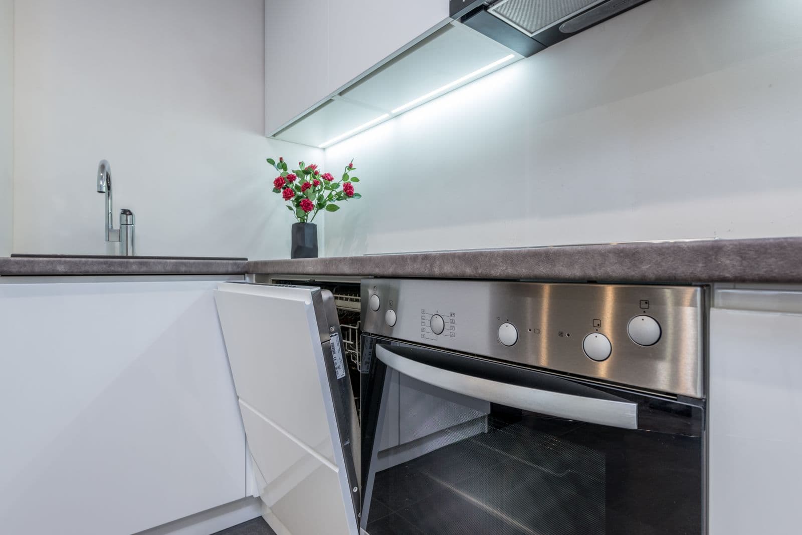A stainless oven with its door open in a white kitchen