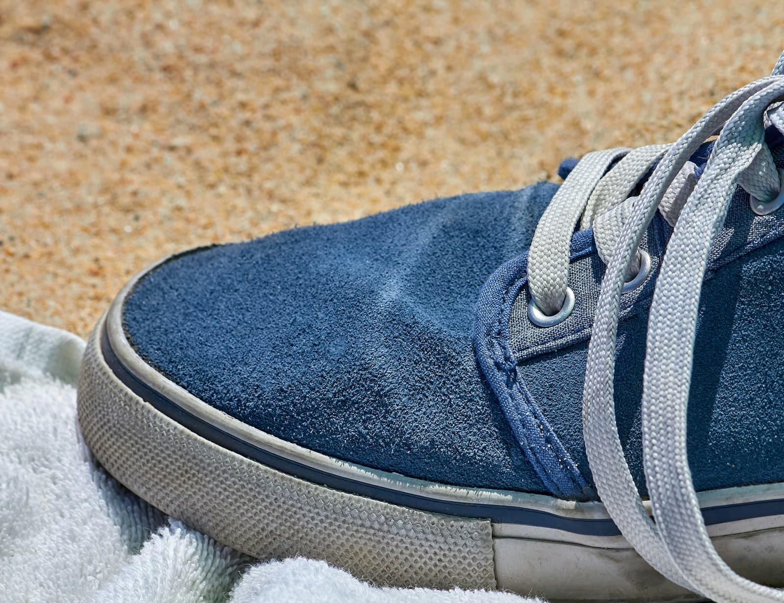 Close-up of a blue suede sneaker resting on a towel